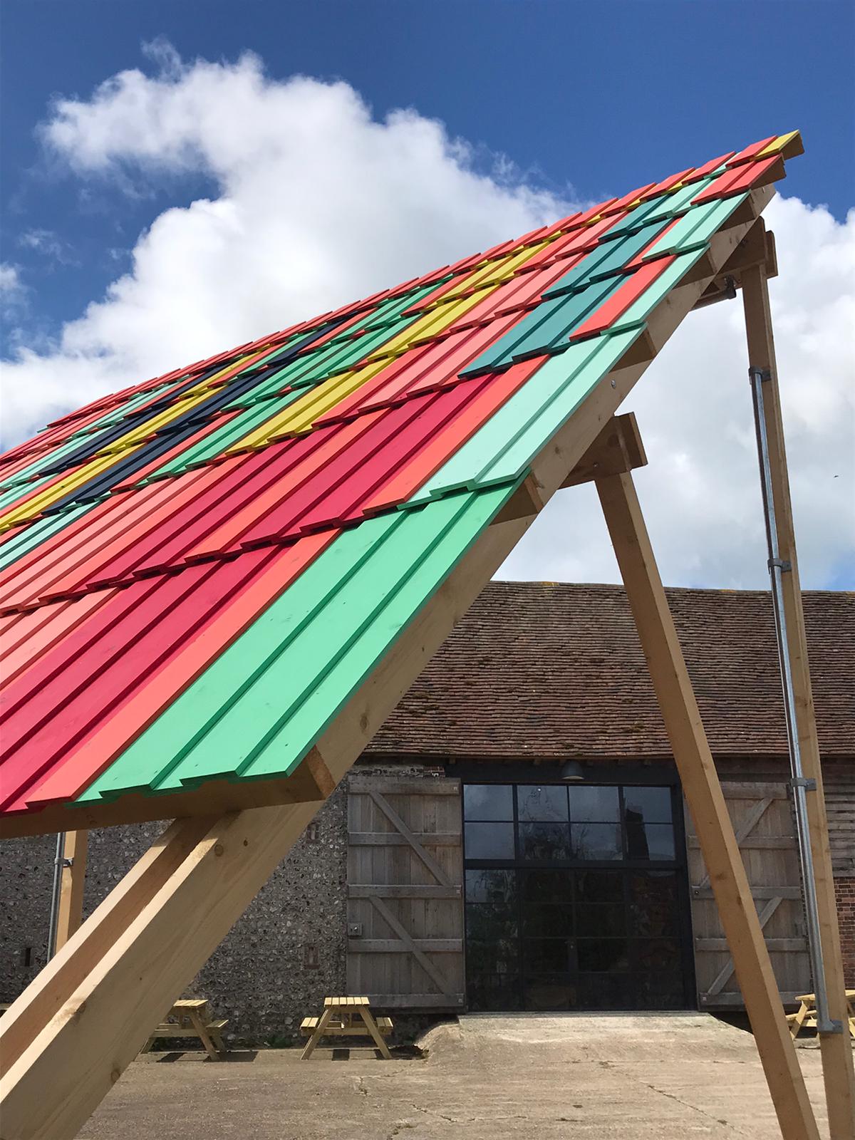 A photograph of a wooden construction - a multi-coloured outdoor stage