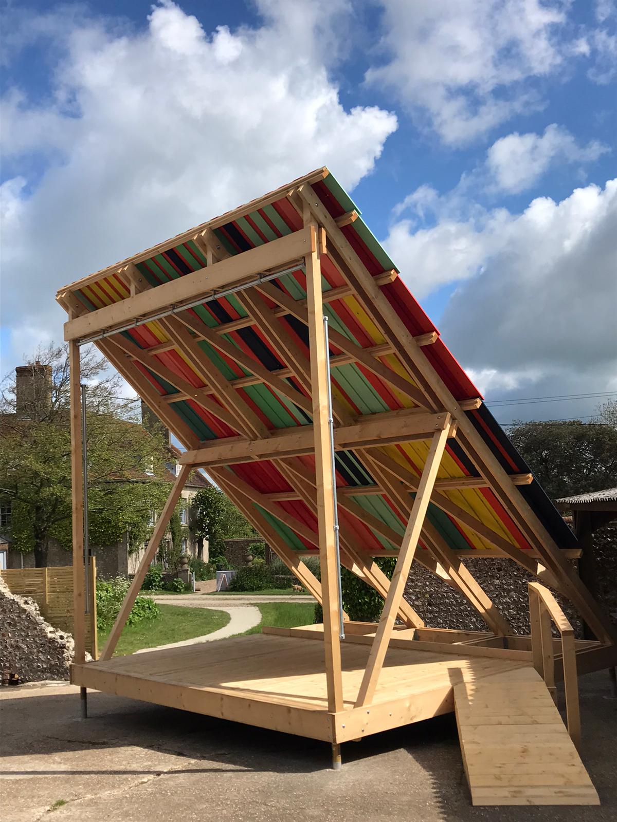 A photograph of a wooden construction - a multi-coloured outdoor stage